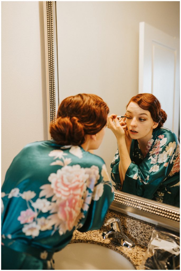 bride doing her own makeup on wedding day