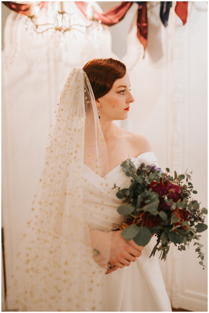 bride hold her bouquet looking to the side with starry veil