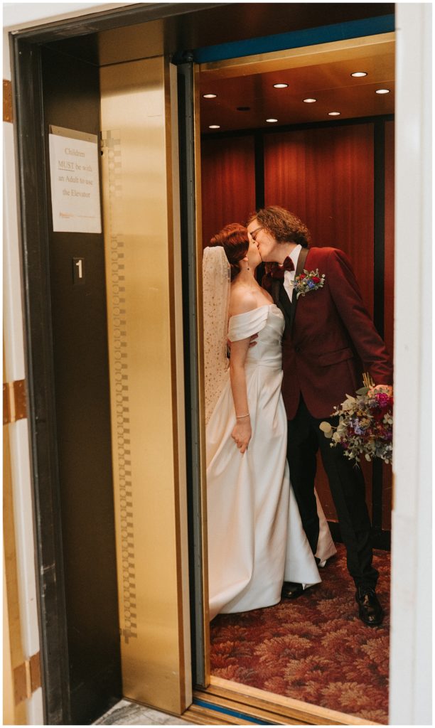 bride and groom kiss in the elevator at their wedding venue