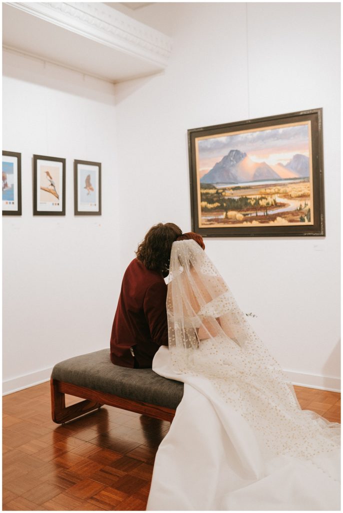 bride and groom look at art in art gallery at Willard Arts Center in Idaho Falls