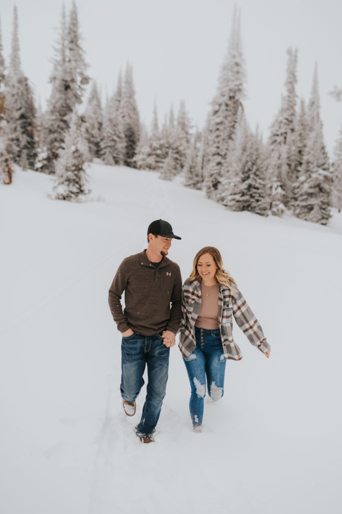 bride and groom walk in the snowy forest, twin falls wedding photographer, engagement session in twin falls